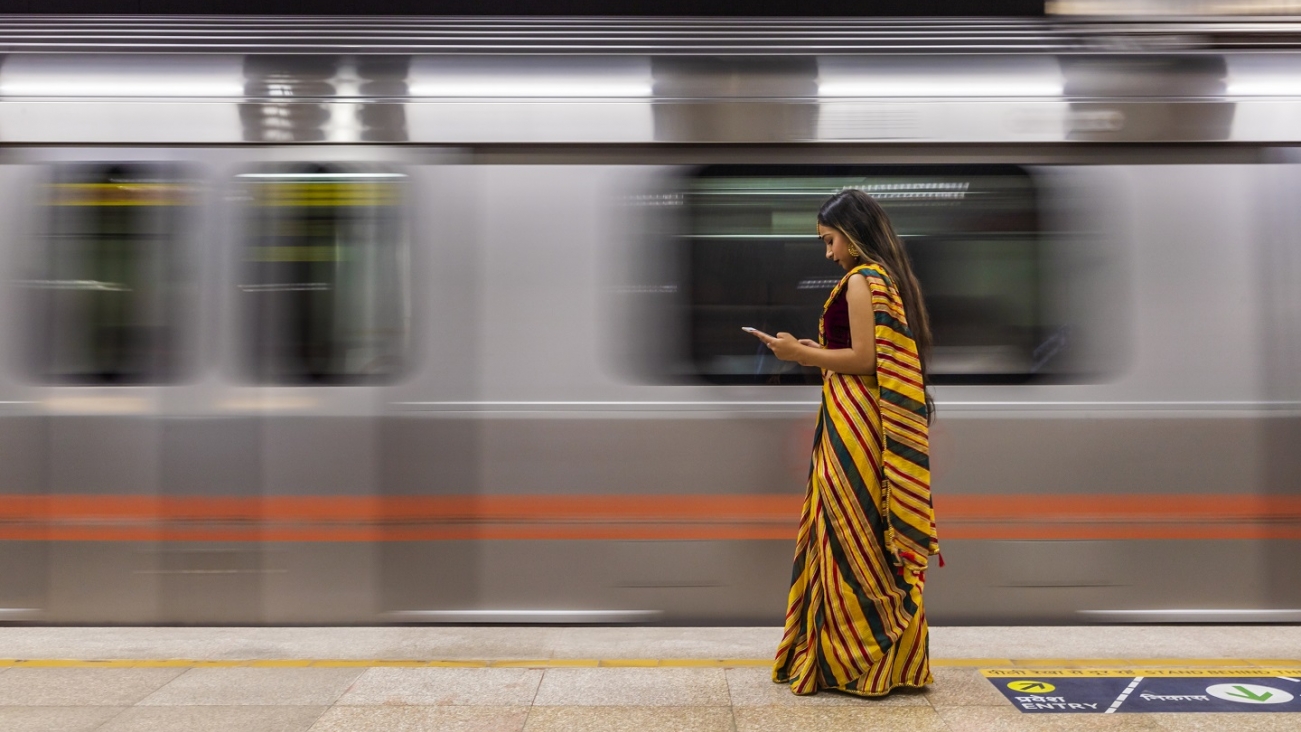 Woman in Yellow At Station Near Speeding Train